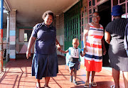 Enzokuhle Tshongwe, 4, and his grandmother Fakazile Nene with his teacher on his first day of school on Wednesday.