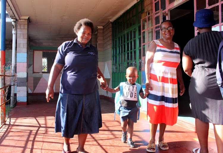 Enzokuhle Tshongwe, 4, and his grandmother Fakazile Nene with his teacher on his first day of school on Wednesday.