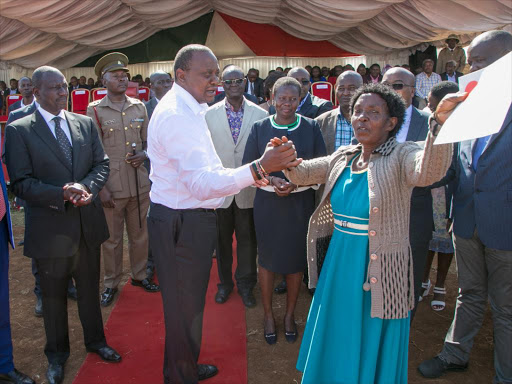 President Uhuru Kenyatta with presents a title deed to a land owner when he kicked off the issuance of 65000 title deeds to Meru County residents at Ncuui, Tigania East./PSCU