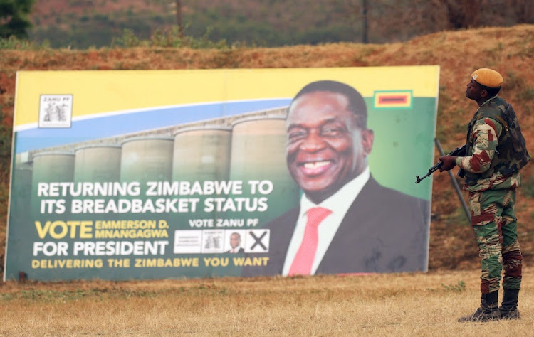 A soldier stands guards in front of an election banner of President Emmerson Mnangagwa's ruling ZANU (PF) party in Bindura, Zimbabwe July 7, 2018.