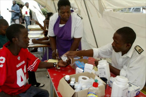 Patients receive medication at a typhoid screening and treatment at a clinic in the Kuwadzana township on the outskirts of Harare on January 31, 2012.