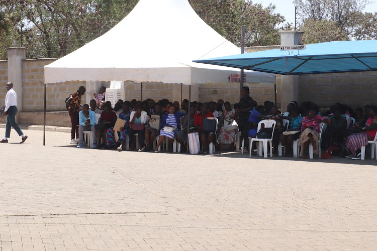 Some employees under tents as they wait for verification of their documents before getting January salaries at the county headquarters in Homa Bay town on February 15,2023