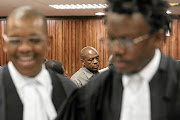 Supra Mahumapelo (centre) talks to journalists during a brief adjournment at the high court in Johannesburg, where the ANC's disbanded  North West provincial executive committee  won reinstatement yesterday.  / Alaister Russell