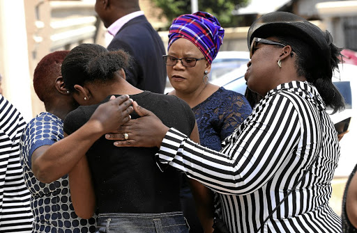 Emmanuel Tshivhase's daughter Ompha is comforted by Lindiwe Madyungu, Boitshepo Senosi and Agnes Nathane outside her home in Protea North, in Soweto.