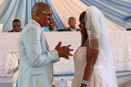 UNITED HEARTS: Mandla Kameni and Regina Nyikadzino exchange vows in East London at the weekend. He is South African and she is Zimbabwean Picture: ALAN EASON