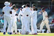 Keshav Maharaj of South Africa is congratulated by team mates after dismissing Nathan Lyon of Australia during day five of the First Test match between Australia and South Africa at the WACA on November 7, 2016 in Perth, Australia.  (Photo by Paul Kane/Getty Images)