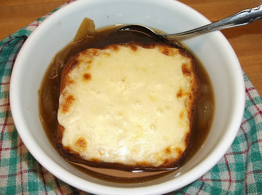 French onion soup topped with toasted sourdough bread with melted mozzarella cheese.