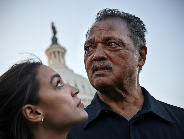 Rep Alexandria Ocasio-Cortez (L) and Rev Jesse Jackson, Jackson has been hospitalised after contracting Covid-19.