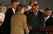 Cuban President Raul Castro (L) and South Africa's President Jacob Zuma shake hands as they attend a massive tribute to Cuba's late President Fidel Castro in Revolution Square in Havana, Cuba, November 29, 2016.