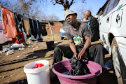 A resident, who didn't want to be named, washes clothing at the Wattville hostel in Benoni, Ekurhuleni on June 28, 2018. The hostel hasn't seen basic service delivery in weeks. 