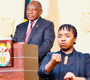 Andiswa Gebashe interprets in sign language alongside President Cyril Ramaphosa. 