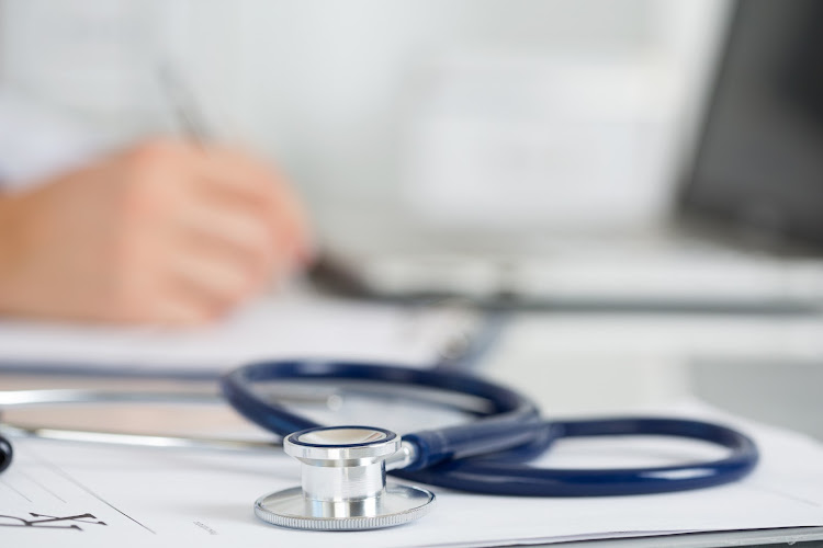 Medicine doctor's working table. Focus on stethoscope. Male medicine doctor operating on background.