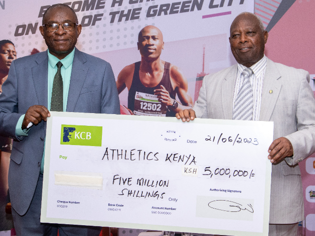 KCB's representative George Odhiambo (L) with Athletics Kenya President Jackson Tuwei during the unveiling of Sh5m cheque at Nolfolk Hotel Nairobi on June 21