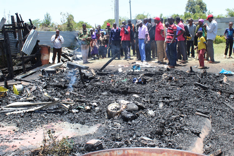 Residents mill around the scene of the incident at Kesebek in Bomet east where husband, wife and child died.