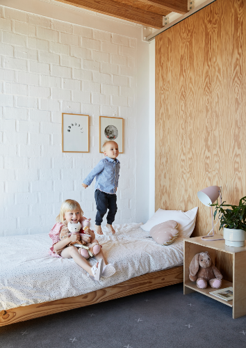 Frankie (5) and Grayson (2) Long on a built-in bed in their bedroom on the first floor of their home. The simple bedside pedestal was made by David, and the pink table lamp was found at a local retailer.