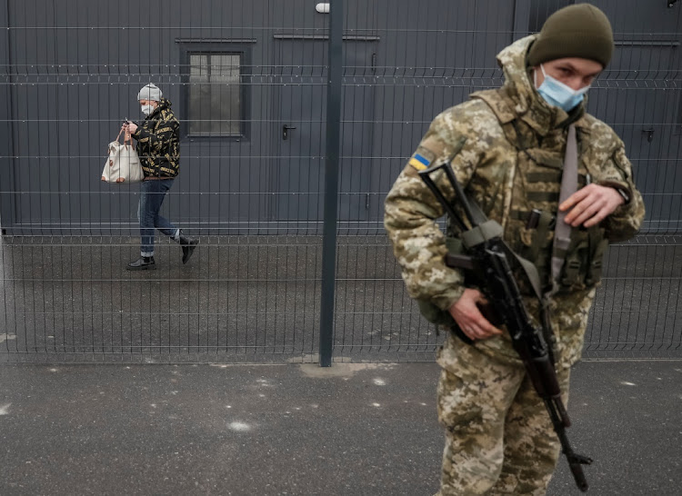 A woman crosses the contact line between pro-Moscow rebels and Ukrainian troops in the settlement of Stanytsia Luhanska, Ukraine, on February 23 2022. Picture: REUTERS/GLEB GARANICH