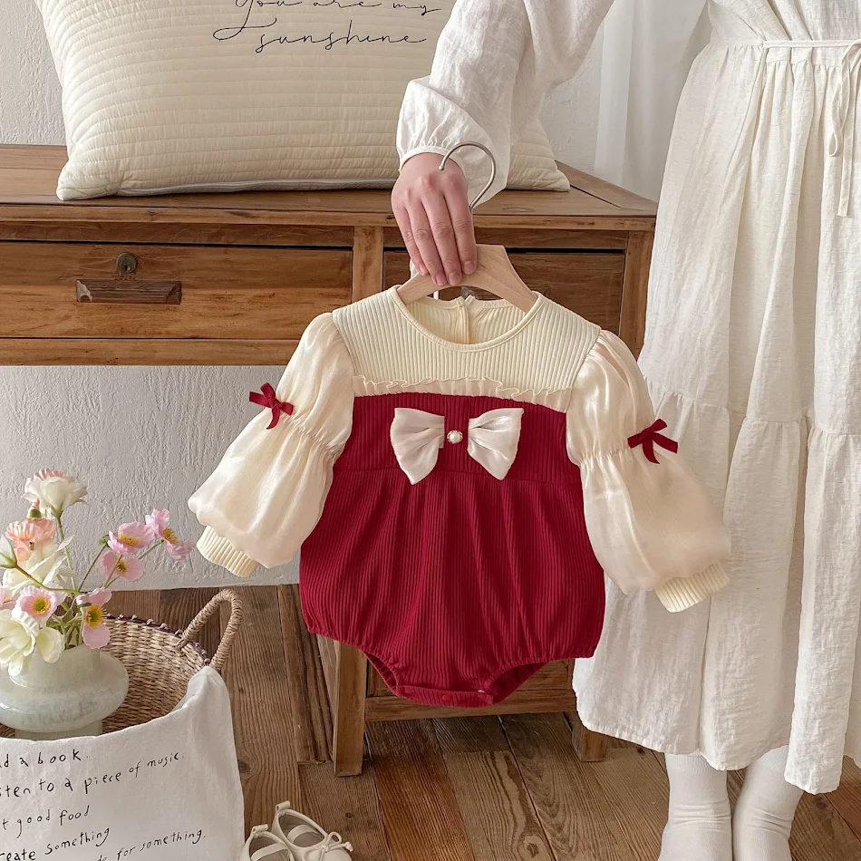 Baby Jumpsuit Strik Puffmouw Volledige Bedekking. Schattige jumpsuit voor baby's, met strik, pofmouwen en volledige bedekking voor comfort.