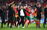 Morocco coach Walid Regragui celebrates with the team after their 1-0 World Cup quarterfinal win against Portugal at Al Thumama Stadium in Doha, Qatar on December 10 2022. 