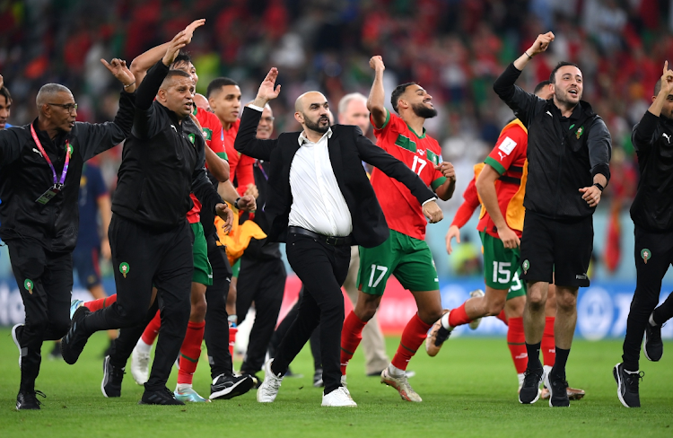 Morocco coach Walid Regragui celebrates with the team after their 1-0 World Cup quarterfinal win against Portugal at Al Thumama Stadium in Doha, Qatar on December 10 2022.