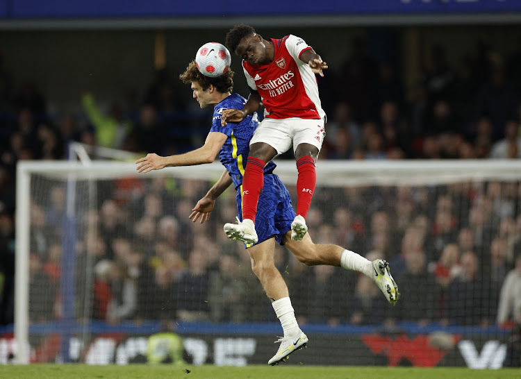 Arsenal's Bukayo Saka vies for an aerial ball with Chelsea's Marcos Alonso