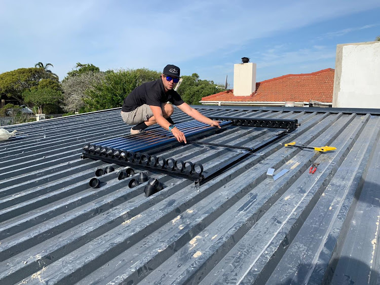 Craig Wood, of CAW Plumbing, works on a roof installation