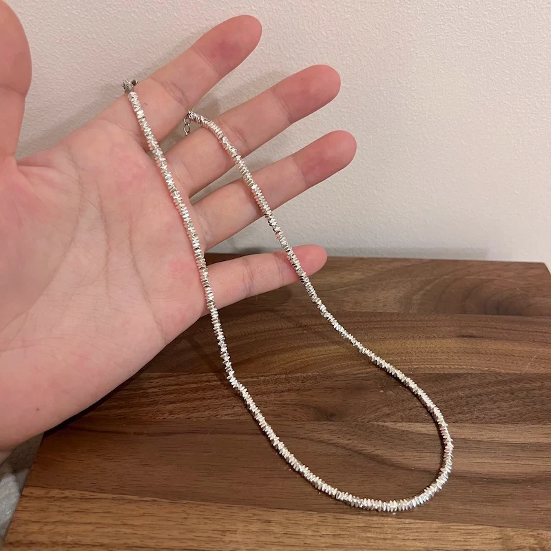 Vrouwenketting met kleine zilveren parels, choker en sleutelbeenketting. Subtiele elegantie om je schoonheid te accentueren.