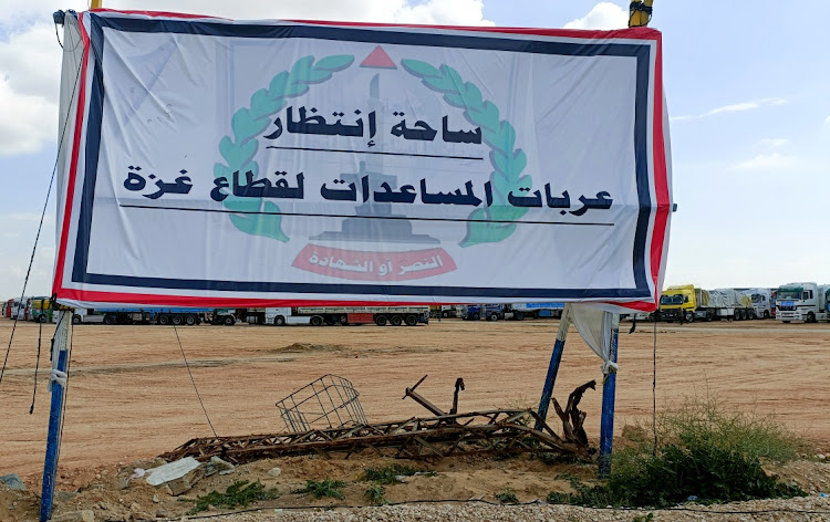 Aid trucks are lined up next to a large cement fence near the border with Gaza, which Egypt says will be a logistics zone to receive aid for Gaza, amid the ongoing conflict between Israel and Palestinian Islamist group Hamas, in Rafah, Egypt, on February 20, 2024. Picture: REUTERS/Stringer