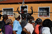 People queue for food parcels in Kliptown, Soweto. Many South Africans have lost their jobs and businesses during the pandemic. File photo.