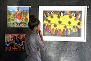 Phindile Mkhize from the African Art Centre looks at a work by Ezequiel Mabote.