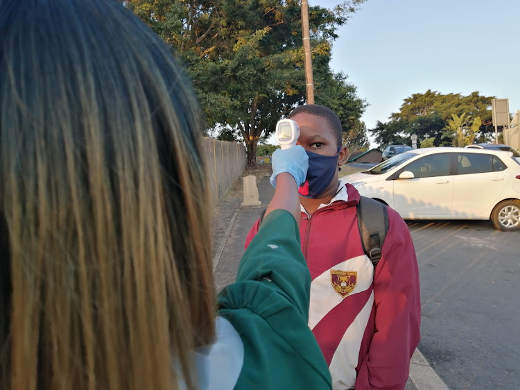 Lwazi Seme, 12, gets his temperature checked as he enters Queensburgh Primary School. Being appointed a prefect, he says he is expected to lead by example.