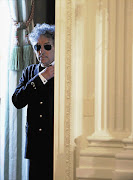 Musician Bob Dylan adjusts his tie as he waits backstage prior to receiving a Presidential Medal of Freedom in the East Room of the White House in Washington, May 29, 2012.