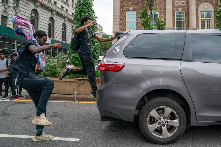 People hit a vehicle of a person driving after popular live streamer Kai Cenat announced a "giveaway" event that grew chaotic, prompting police officers to respond and disperse the crowd at Union Square and the surrounding streets, in New York City, US August 4, 2023.
