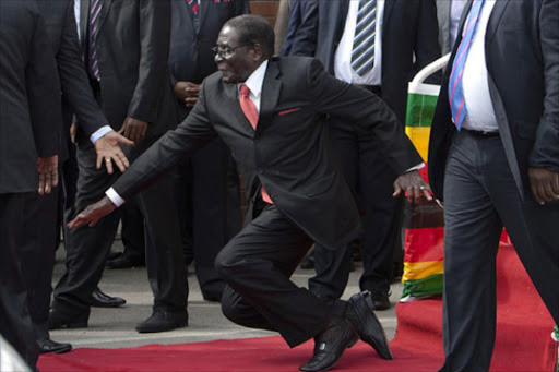 Zimbabwe's President Robert Mugabe falling off a dais after addressing supporters at Harare International Airport. Photo/COURTESY