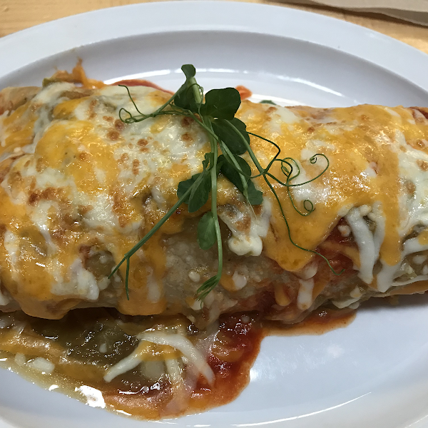 Gf breakfast burrito Christmas style. Filled w sweet potatoes, over easy eggs and black beans and I added local sausage. Both red and green chile sauces are gluten free. Brown rice tortilla.