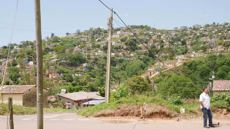 eThekwini urban designer and photographer Prakash Bhika stands on a road in front of Welbedacht's rolling hills in KwaZulu-Natal.