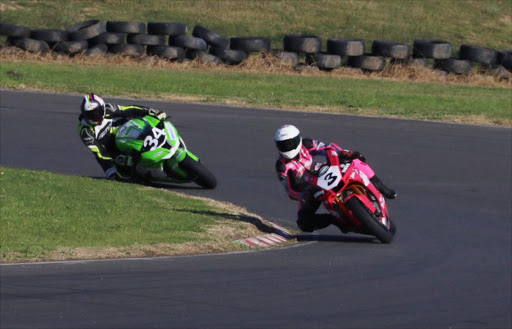 Clint Seller (pink) and Greg Geldehuys (green) come flying around the corner during the second round of DEOD Super GP championship at the EL grand prix track .PICTURE: Michael Pinyana ©DAILY DISPATCH