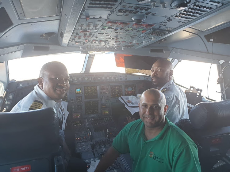 Ahmed Bham, head of the health department's disaster medicine department, with SAA chief pilot Capt Vusi Khumalo, left, and senior first officer Jacob Setlhake on board the Airbus flight to Wuhan.