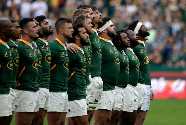 South Africa's flanker and captain Siya Kolisi (R) leads his players as they sing the national anthem ahead of the Rugby Championship international rugby match between South Africa and New Zealand at Emirates Airline Park in Johannesburg on August 13, 2022.