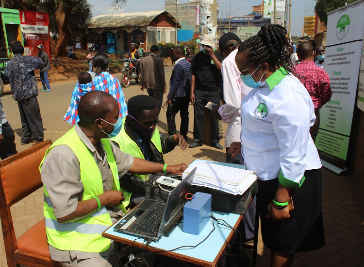 IEBC registration clerks chat with Nyeri county elections coordinator Aluisia Kanini along Gakere road when she led the commission’s officials in mobilising residents in Nyeri town to register as voters.