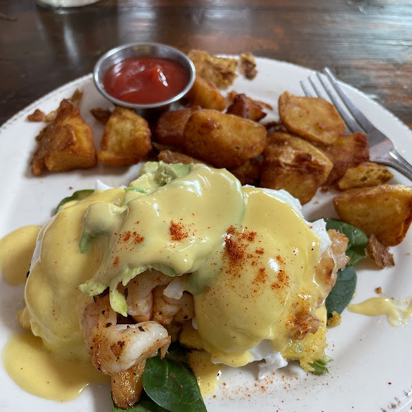 Shrimp and avocado eggs bendict on crispy polenta with breakfast potatoes