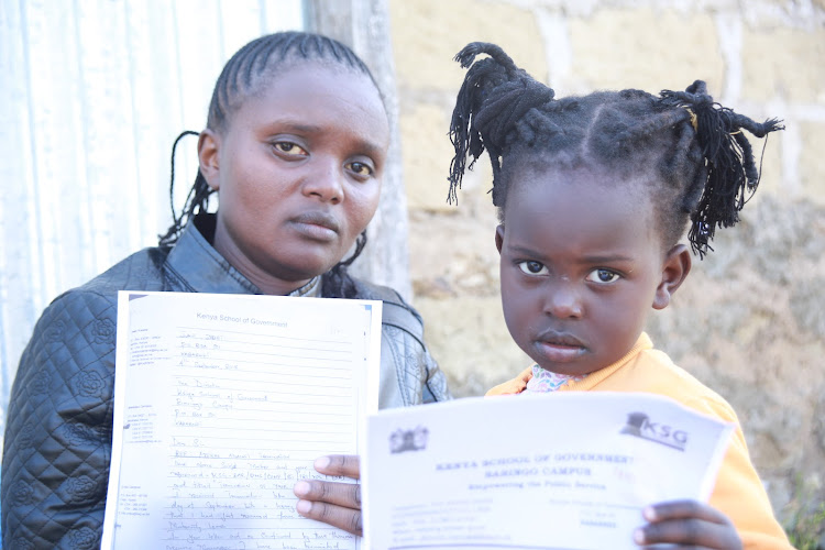 Visually impaired June Jebet with her two-year old daughter Angel displaying job dismissal documents outside their rental house in Kabarnet, Baringo, on Wednesday.