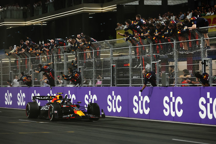 Race winner Sergio Perez passes his team celebrating on the pitwall during the F1 Grand Prix of Saudi Arabia.