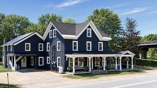 Dark blue house with porch and solar panels in this luxury farmhouse for sale in Pottersville ($549,000)