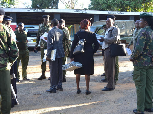 Examination officers (holding KCPE paper) are surrounded by security officers at the examination distribution center at the Kitui county headquarters on Tuesday morning seemingly to ensure the papers were secure./MUSEMBI NZENGU