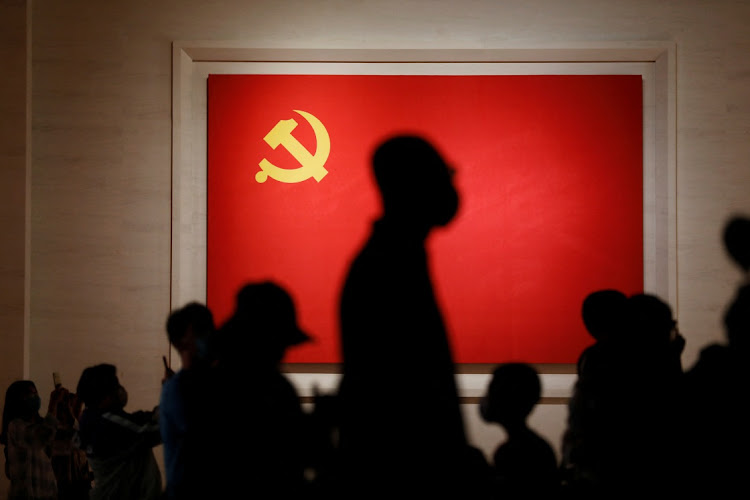 Visitors are seen silhouetted against a Chinese Communist Party flag displayed at the Museum of the Communist Party of China in Beijing, China September 3, 2022. Picture: REUTERS/FLORENCE LO