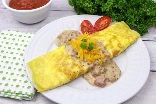 Spicy brunch omelet on a plate with a side of salsa.