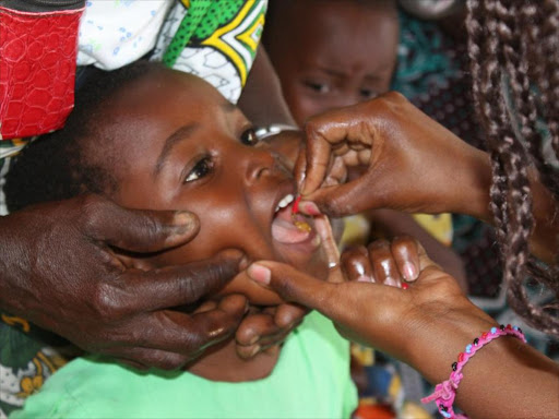 A health officer administers a vaccine to a child.