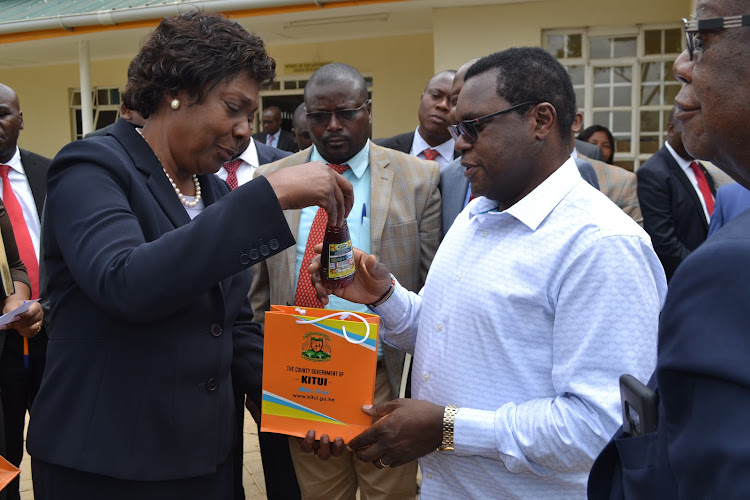 Kitui Governor Charity Ngilu gifts Senate Speaker Ken Lusaka a bottle of Sweet Kitui Honey outside her office on Wednesday