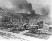 Smoke rises from the ruins of African Americans' homes following the race massacre in Tulsa, Oklahoma in 1921.   