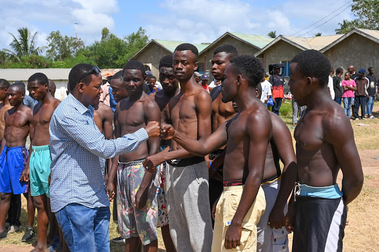 Tourism Cabinet Secretary Alfred Mutua fist-bumps the youth who turned out for the NYS recruitment in in Kilifi on February 7, 2024.